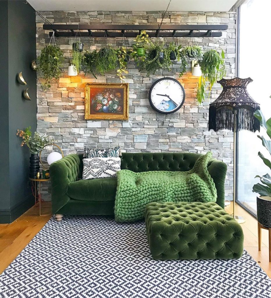 instagram de decoração - sala de estar com sofá verde e chaise, parede de tijolos, abajour preto, plantas penduradas
